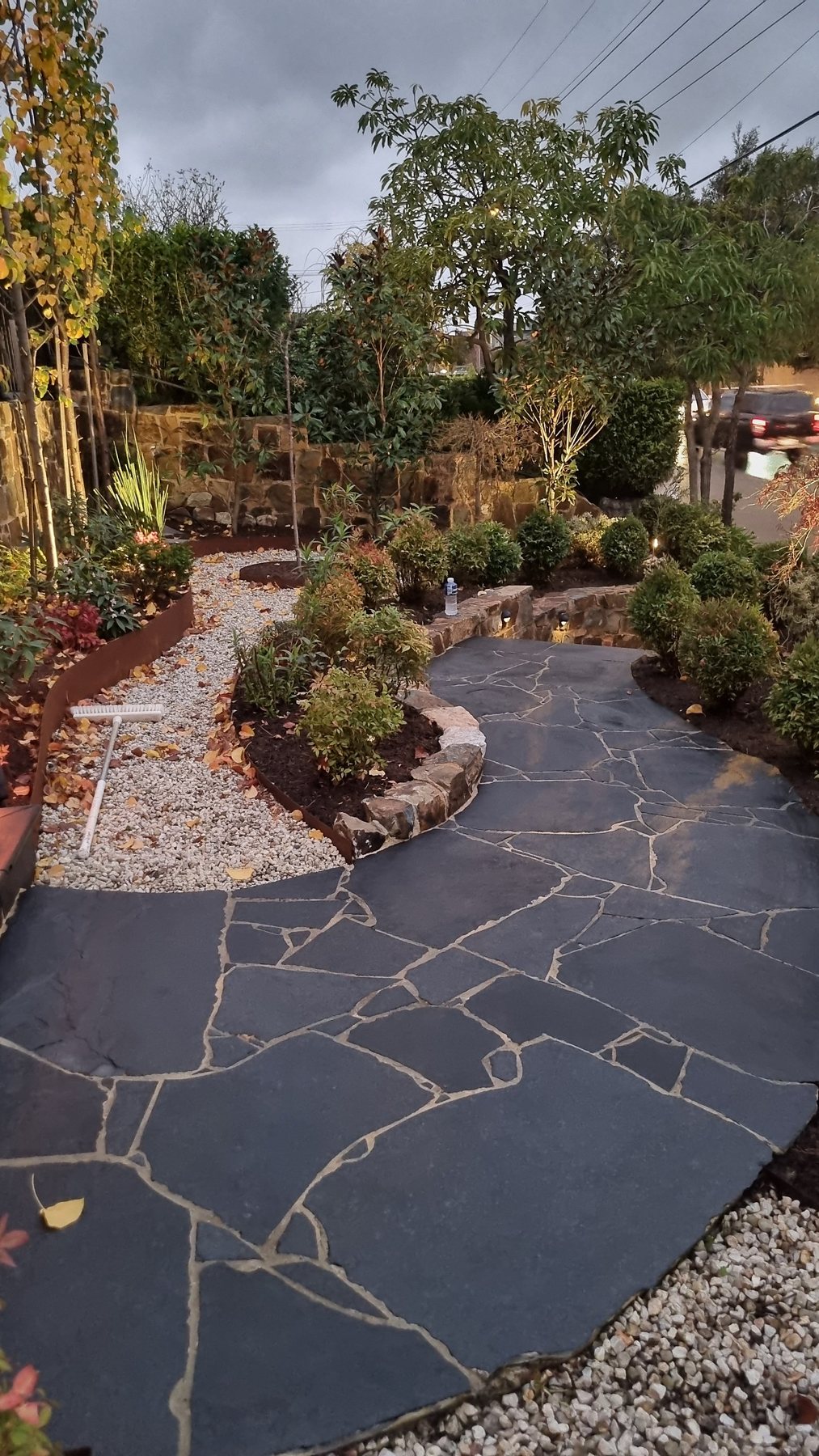 Crazy paving path winding through Corten edged gravel beds