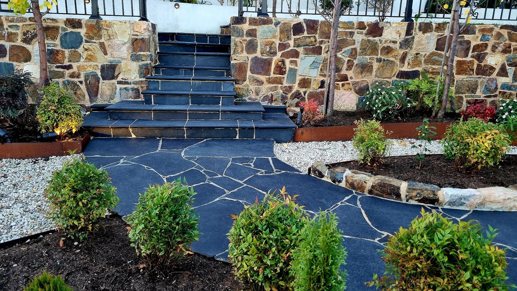 Black stone steps rising between natural stone walls