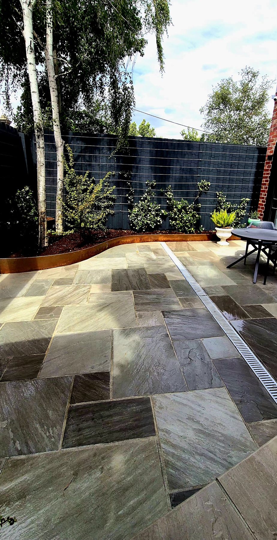 Silver birches, Corten bed and the strip drain through the paving
