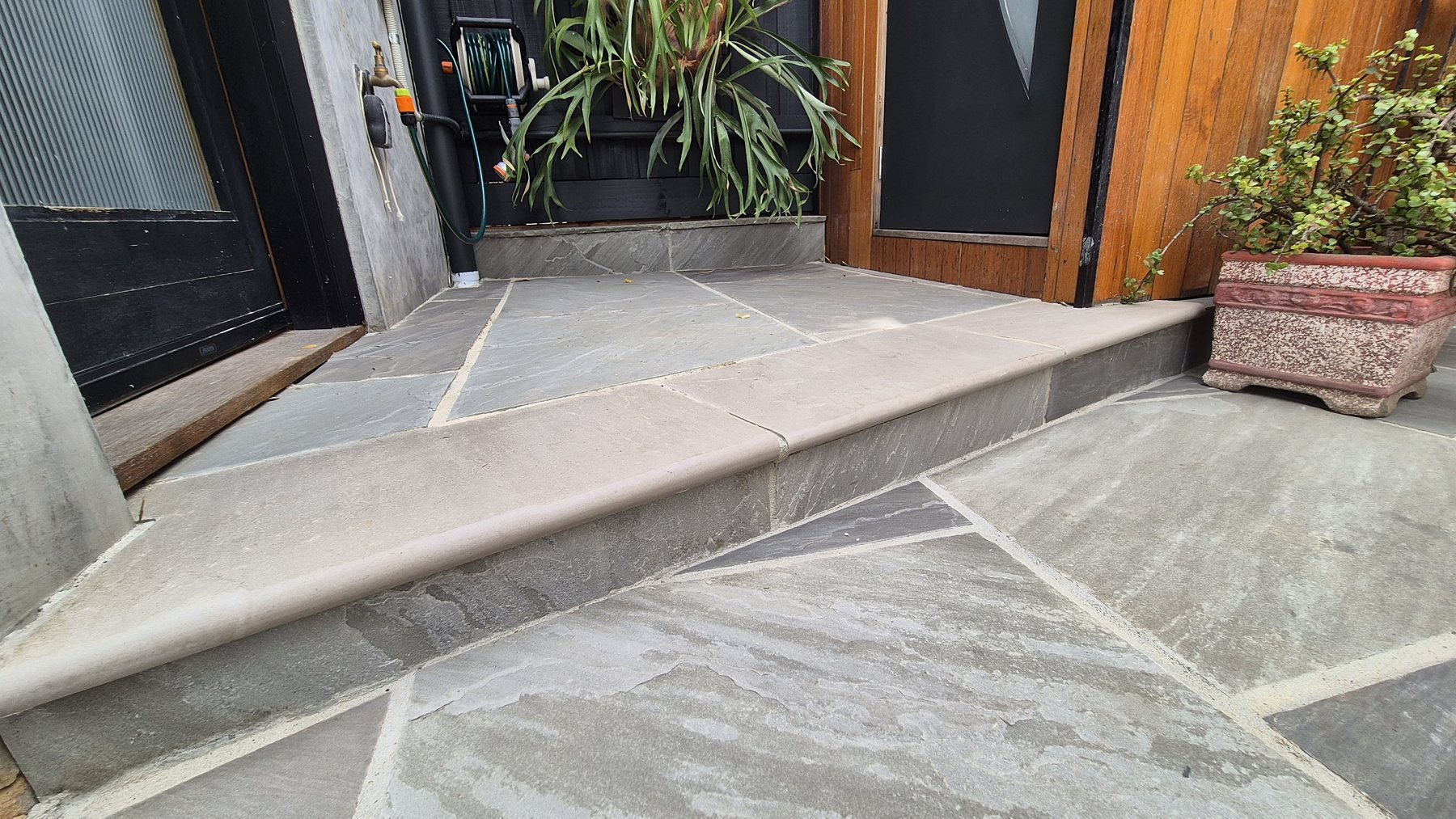 Bullnosed stone step up to the side door