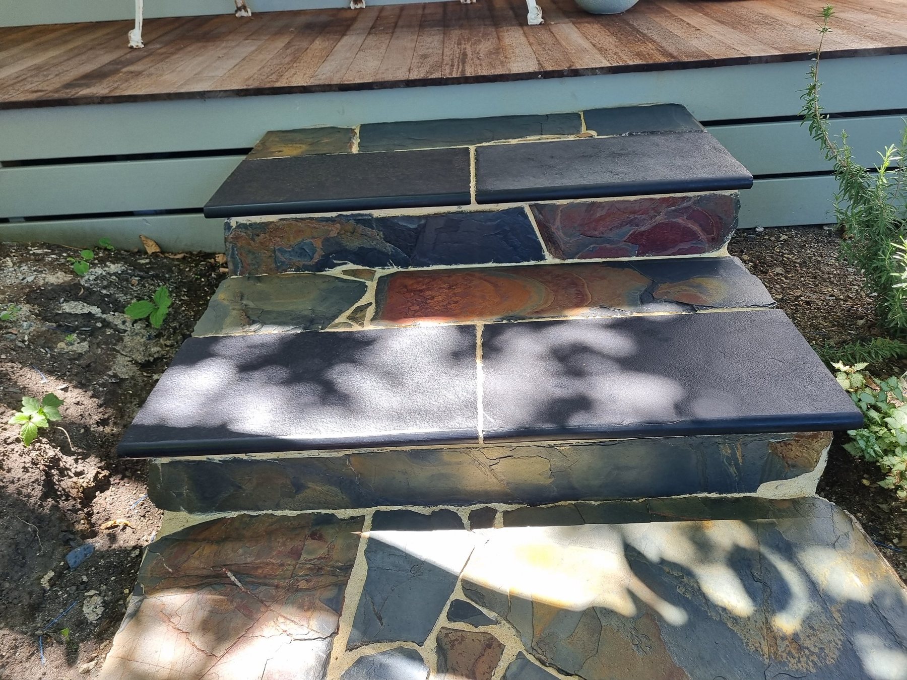 Slate steps with black bullnosed treads up to the hardwood verandah