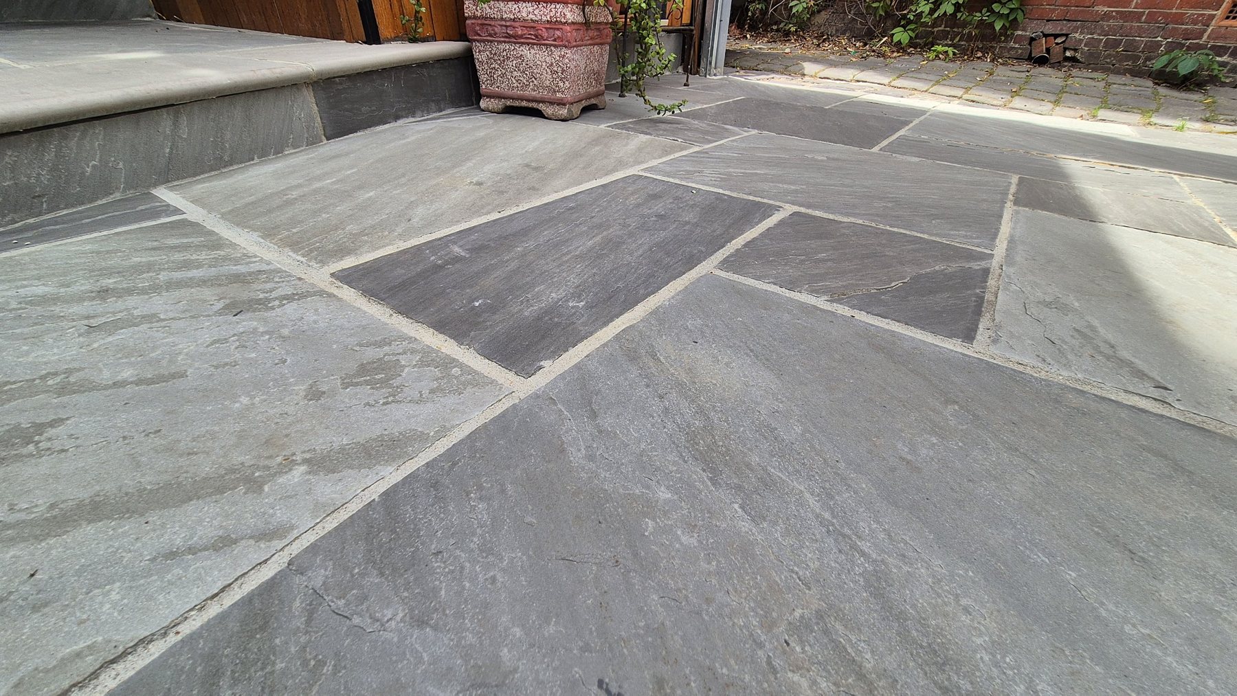 Close view of the stone paving by the step and planter