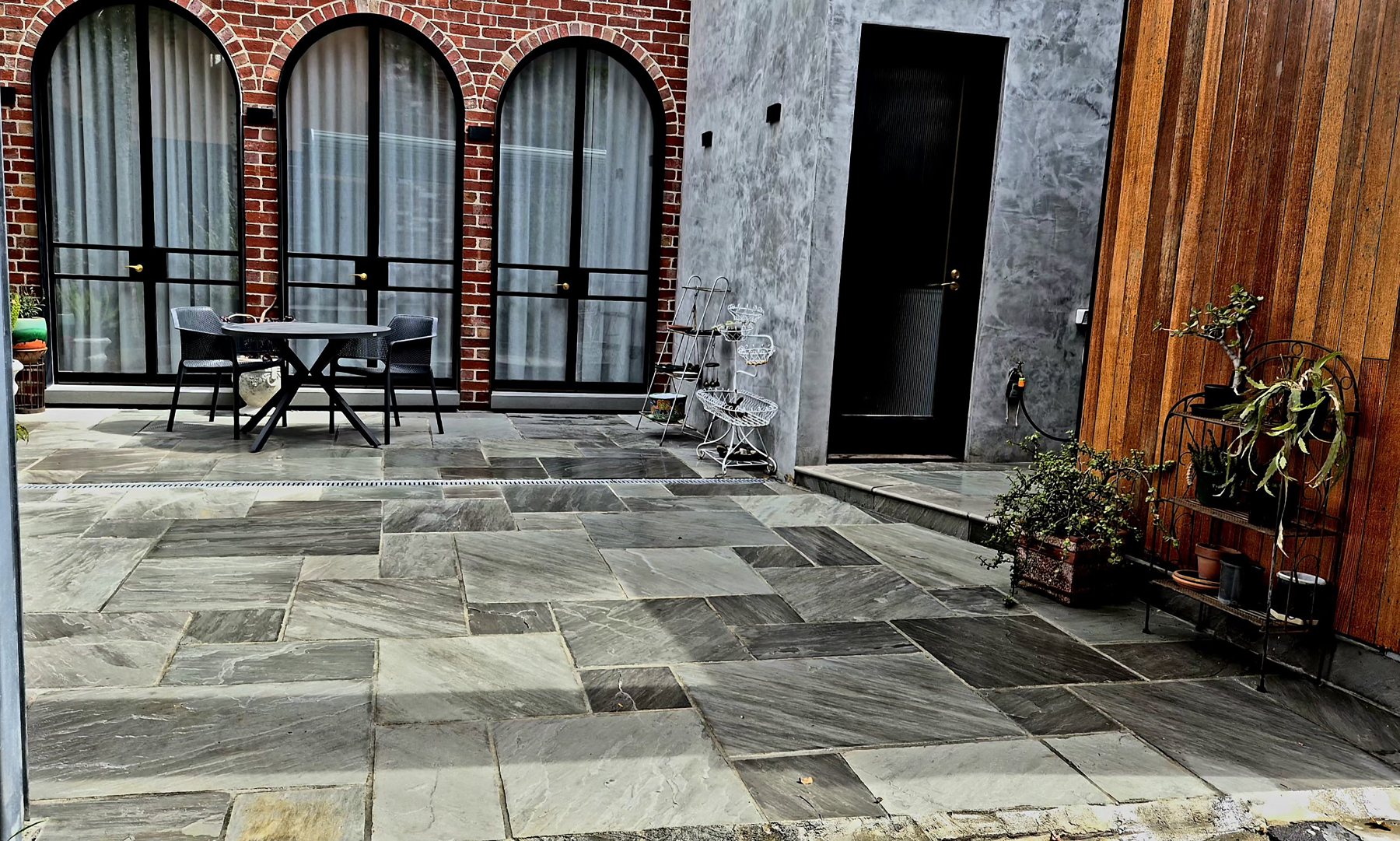 Stone paving in front of the arched windows and rendered wall