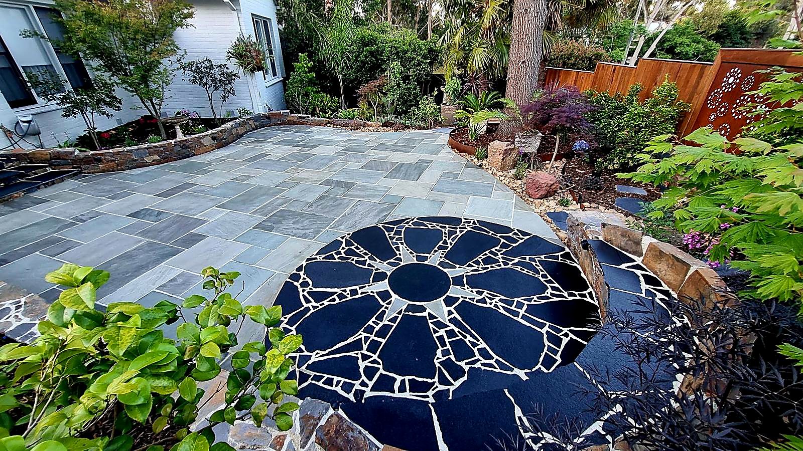 Wide view of the same limestone courtyard with its curved stone edges and planting