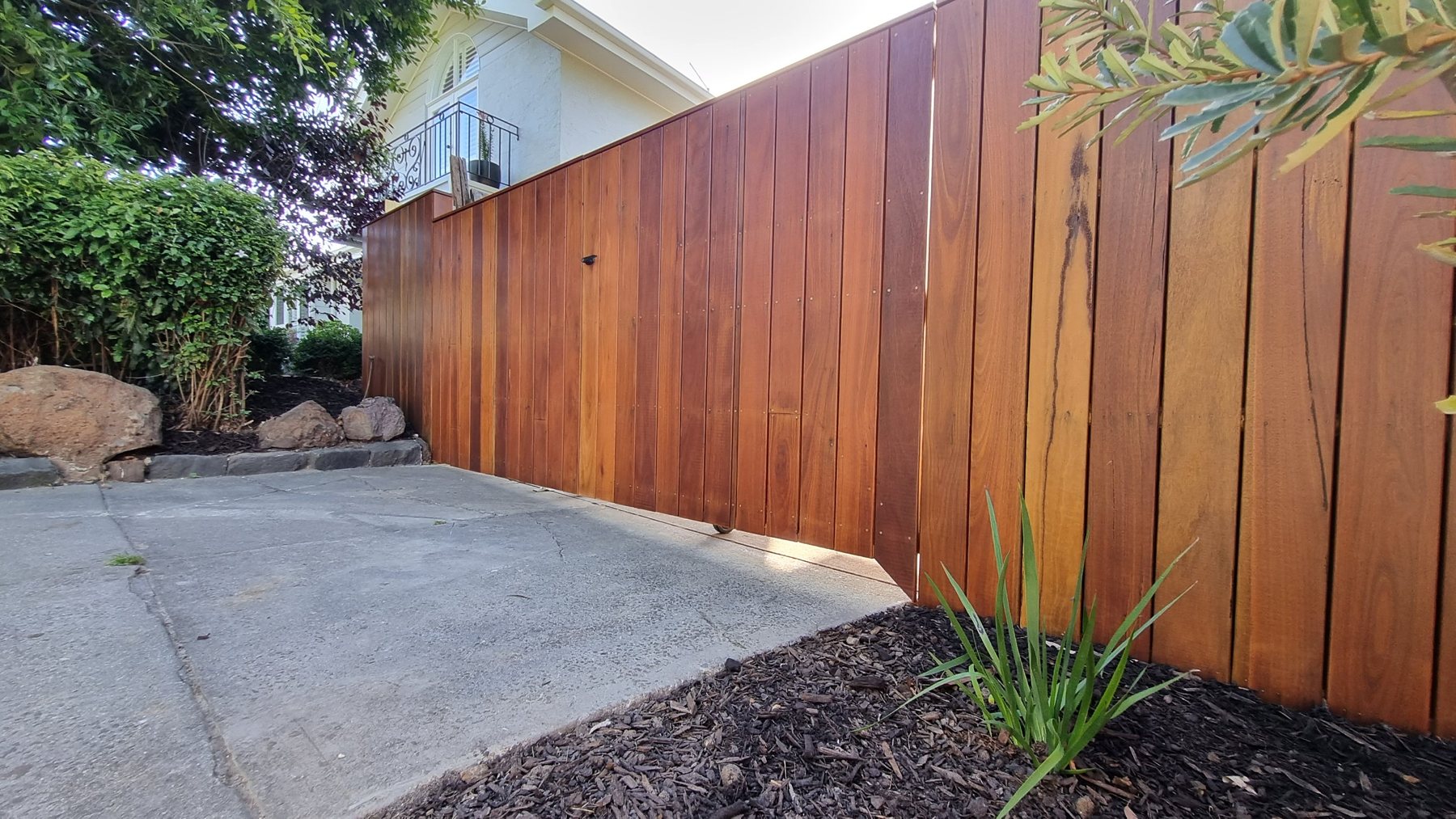 Hardwood sliding driveway gate beside the fence
