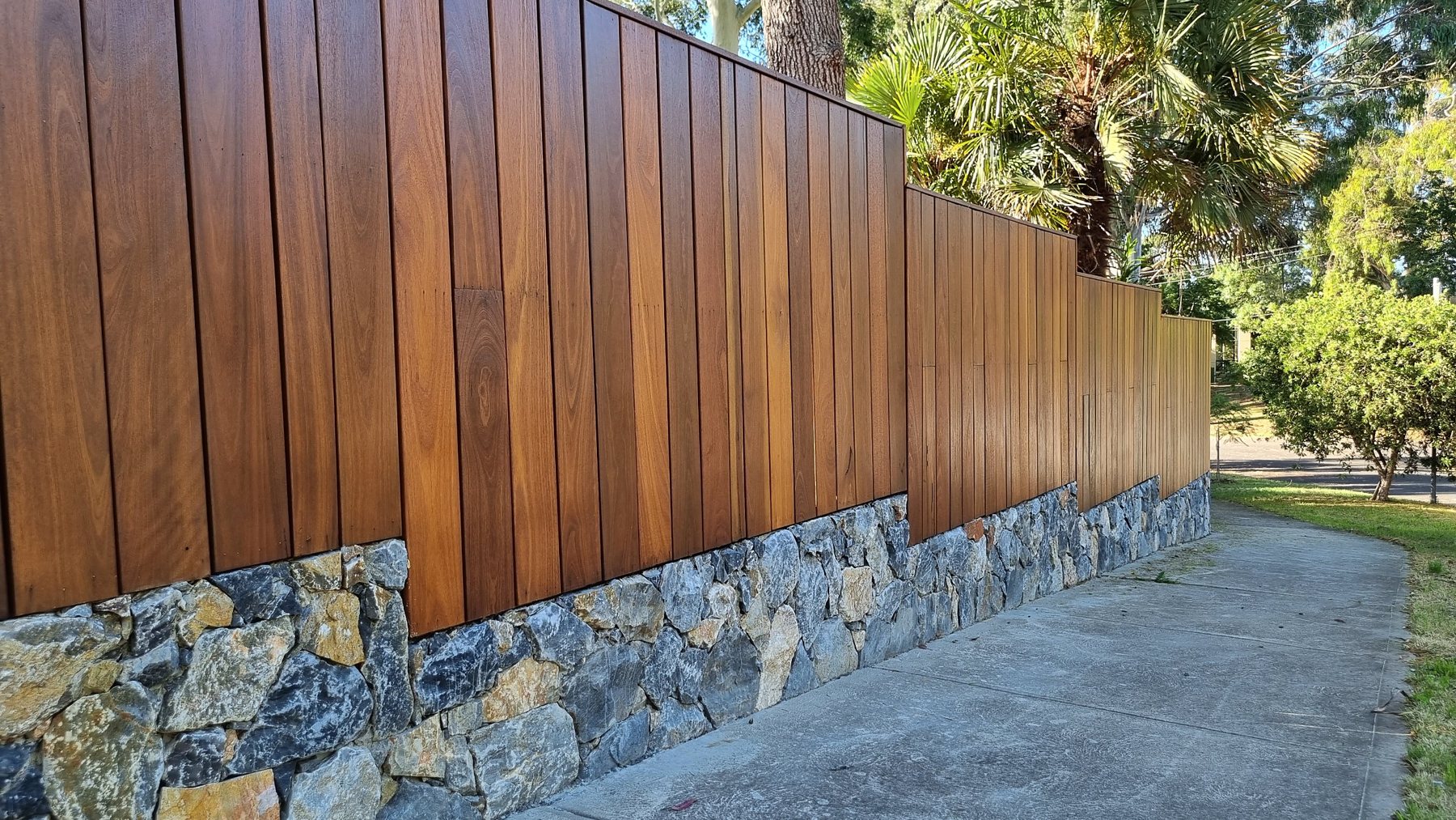 Close view of the hardwood batten fence over the natural stone plinth