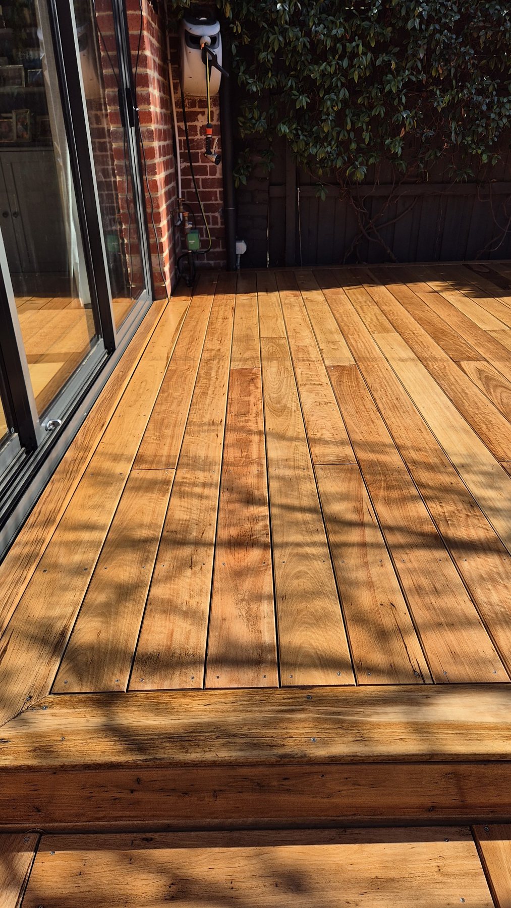 Close view of the oiled hardwood deck boards by the sliding doors