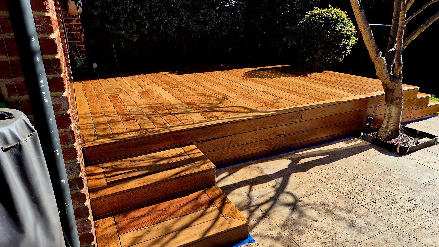 Hardwood deck and side steps over travertine paving