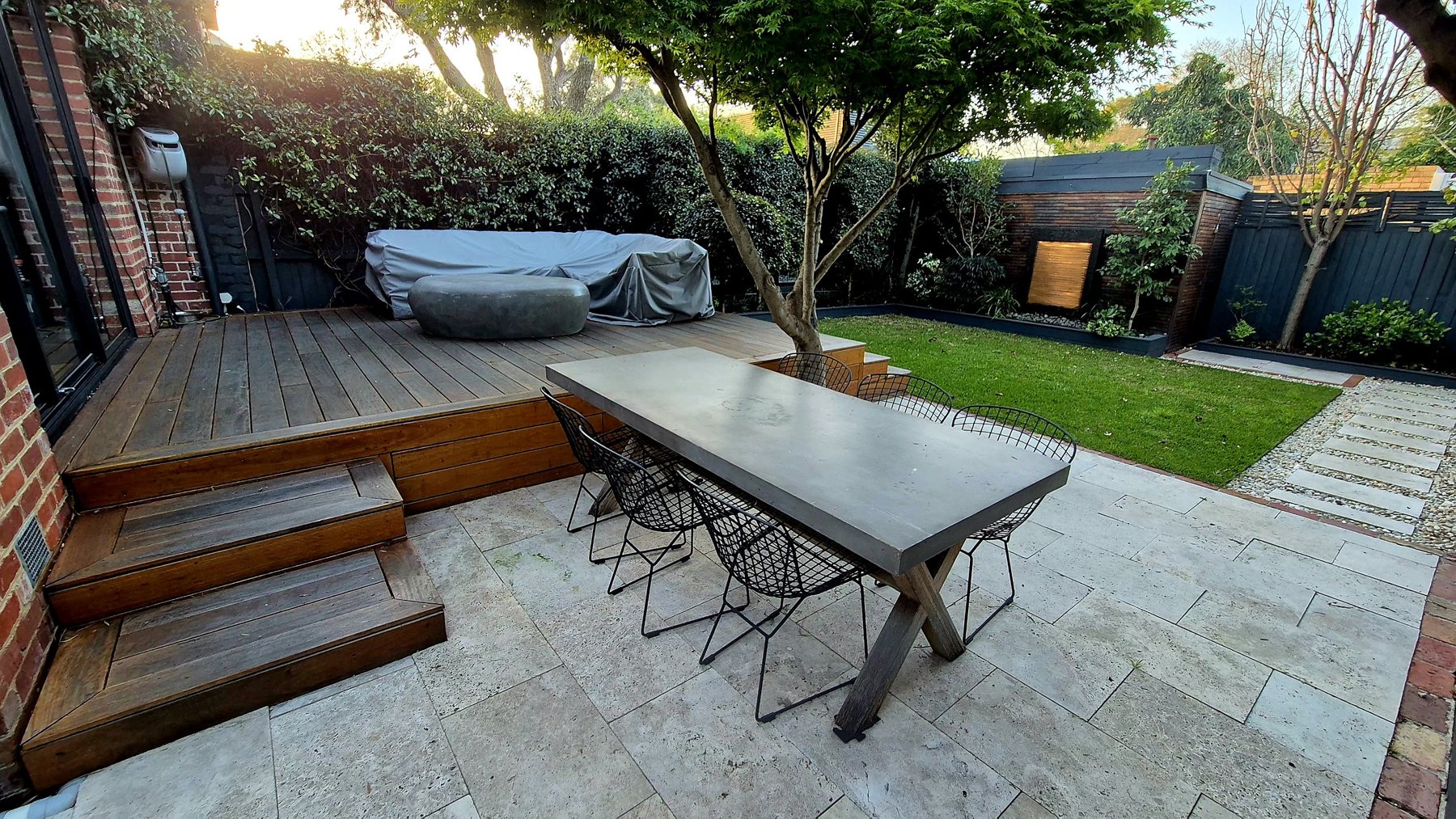 Deck, travertine dining terrace and lawn with the shed water feature