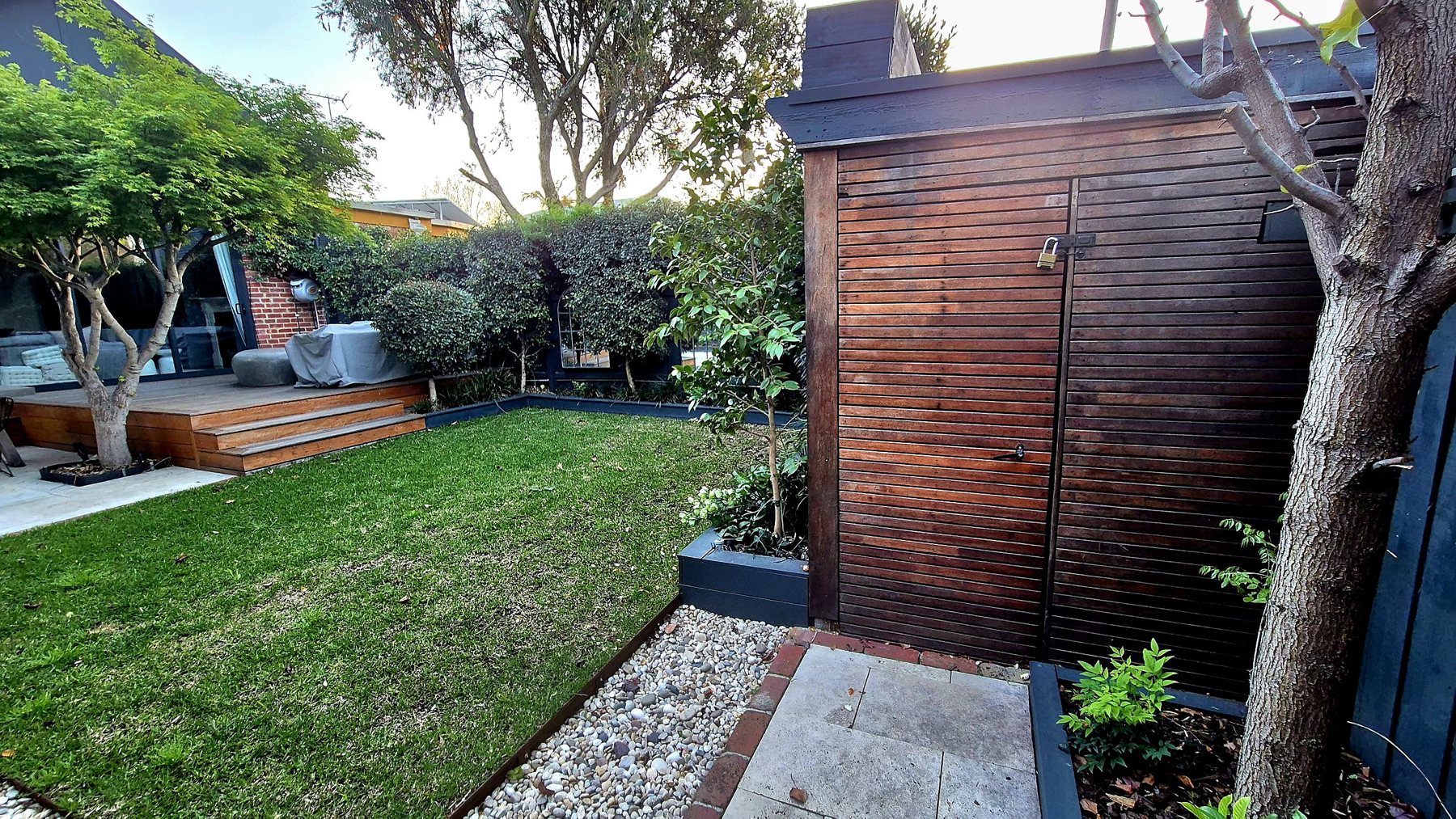 Lawn, slatted hardwood shed and the deck beyond