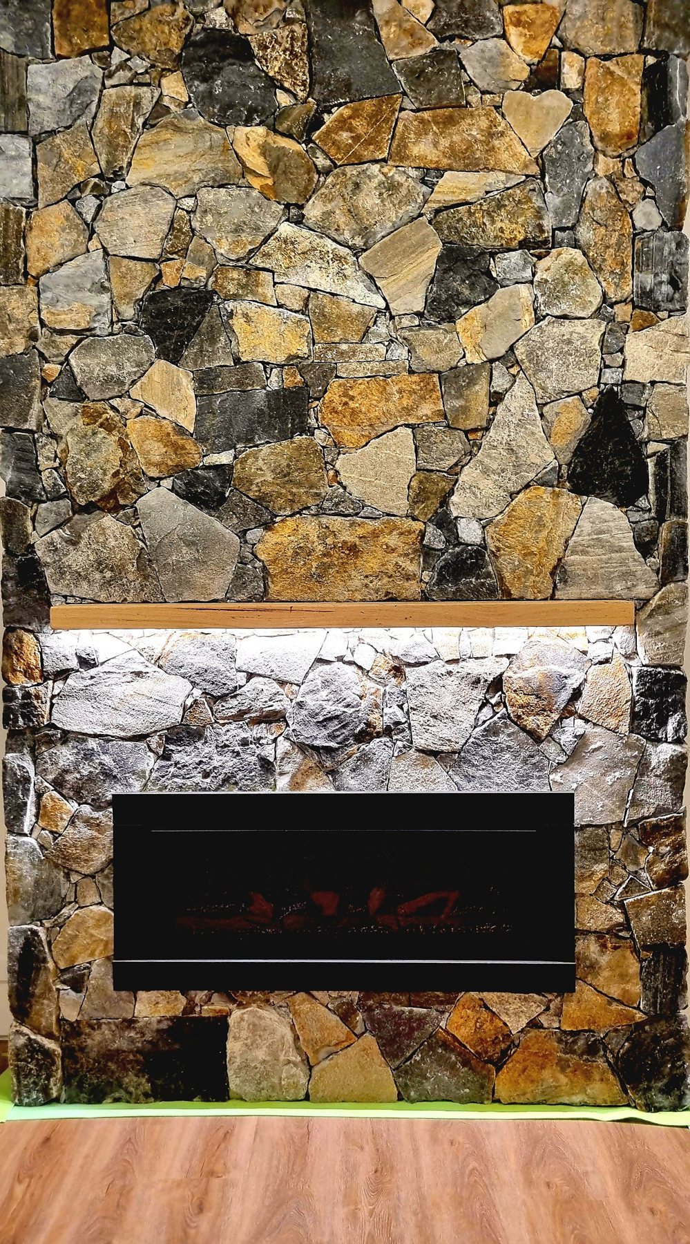 Stone surround and firebox below the lit timber mantel