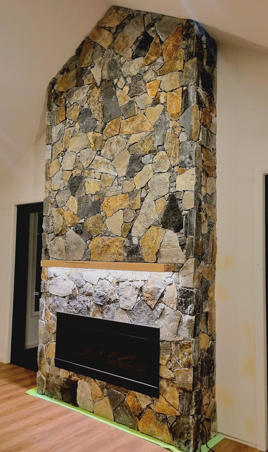 Side view of the natural stone fireplace in the vaulted room