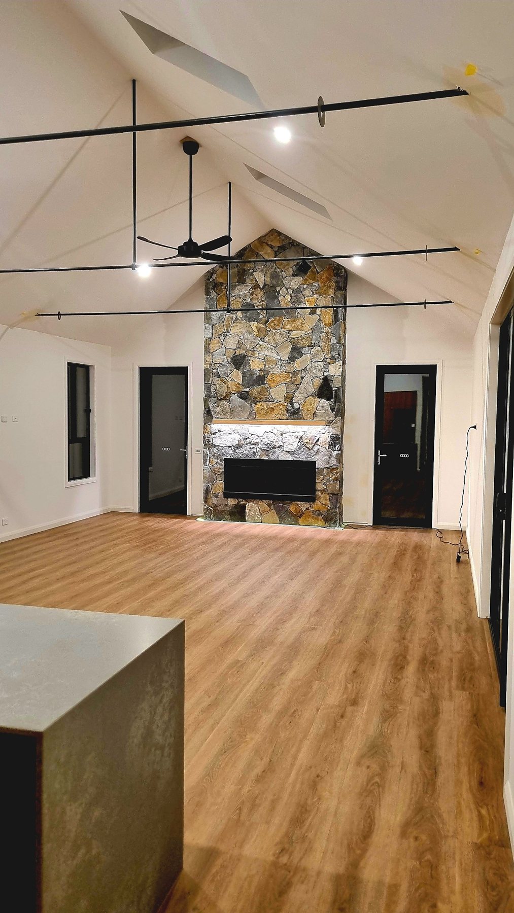 Living room with a vaulted ceiling and a full-height natural stone fireplace