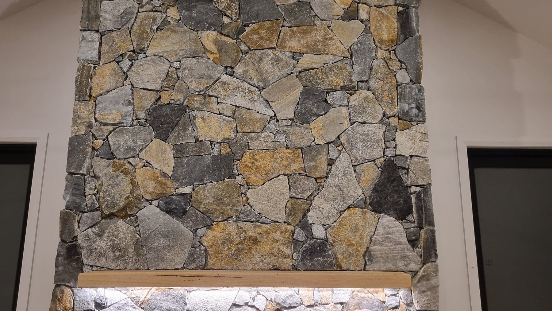 Stonework above the timber mantel, framed by two doors