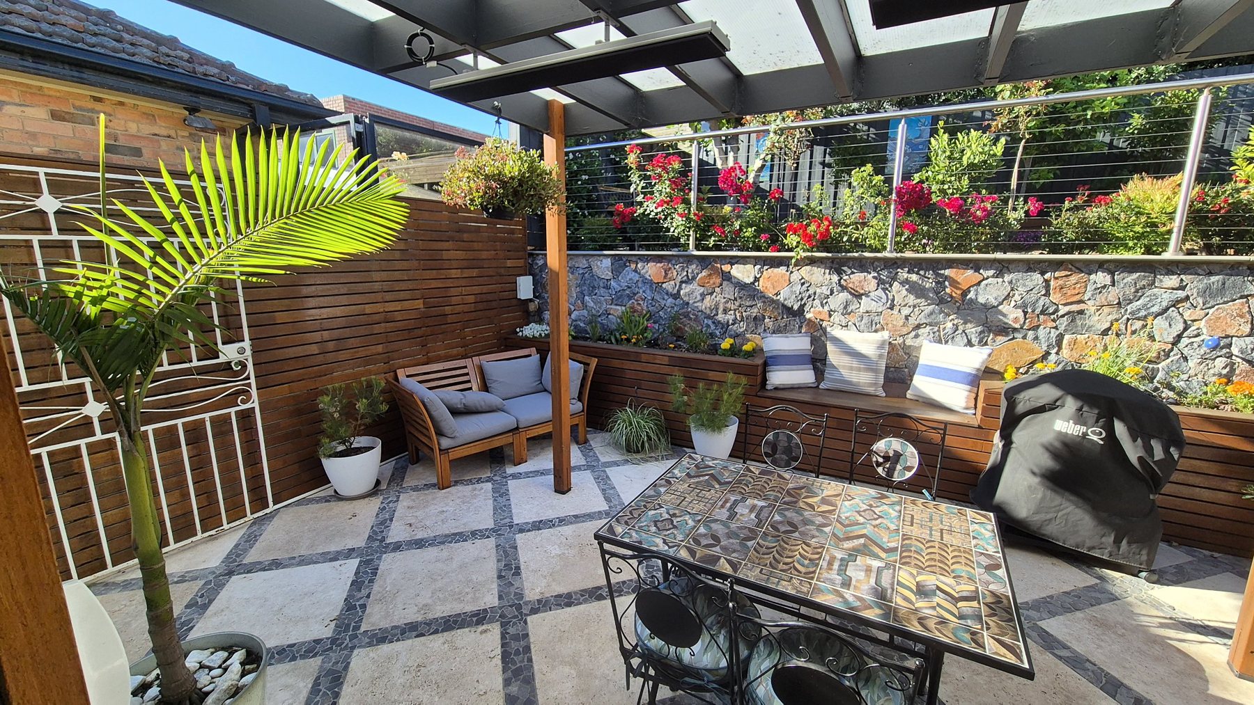 Timber slat screen, planter benches and stone wall around the courtyard