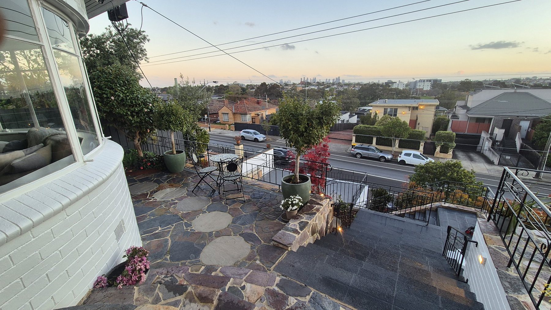Flagstone terrace with stepping pavers overlooking the city skyline at dusk