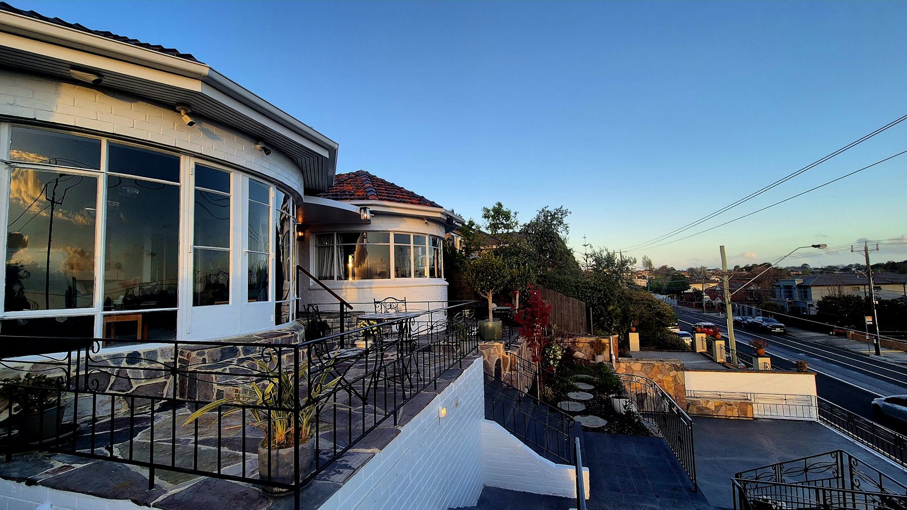 Flagstone terrace and stone walls stepping down to the street at golden hour