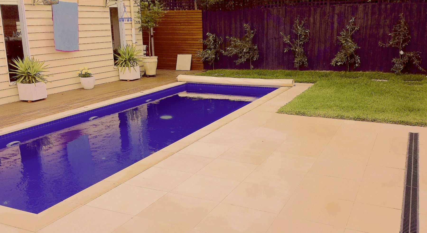 Pool with wide stone paving and a strip drain