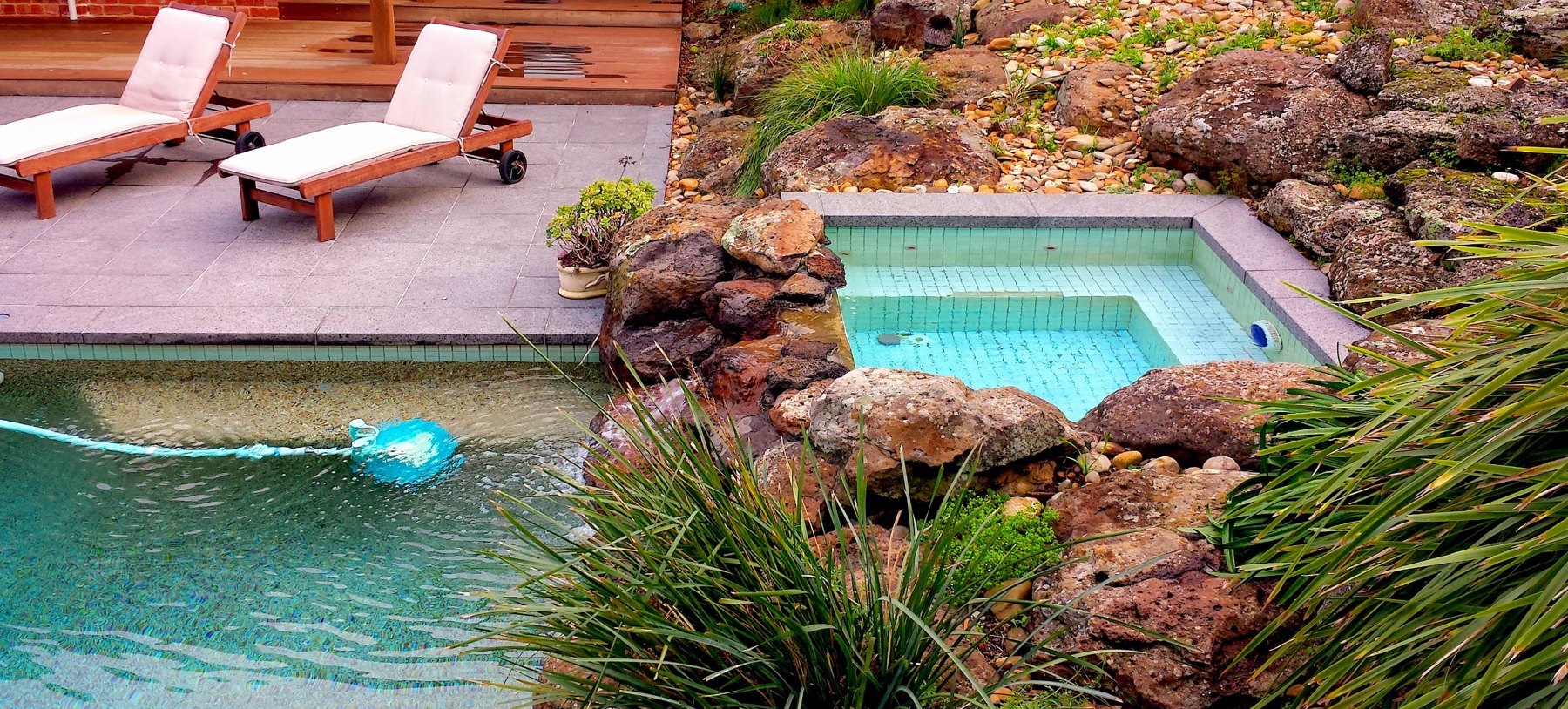 Spa set among natural boulders above the pool