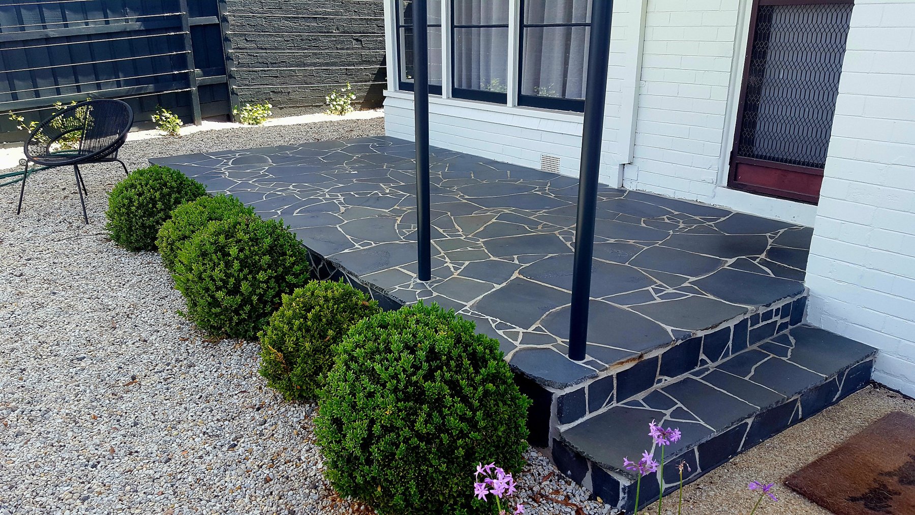 Crazy paving porch and steps edged with buxus balls